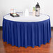 A table with a royal blue Snap Drape box pleat table skirt and a tray of drinks.