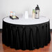 A table with a black Snap Drape bow tie pleat table skirt.