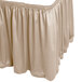 A beige shirred pleat table skirt with a ruffled edge.