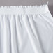 A white Snap Drape table skirt with ruffles and a seam.