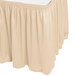 A cream Snap Drape table skirt with shirred pleats on a table.