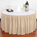 A table with a cream shirred pleat table skirt and velcro clips with a tray of coffee cups.