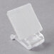 A close-up of a clear plastic Velcro clip with a white square on it.