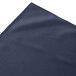 A folded navy blue Snap Drape table skirt with shirred pleats.