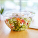 A salad in a clear plastic Eco-Products salad bowl.