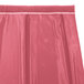 A dusty rose Snap Drape box pleat table skirt with Velcro clips on a table.