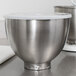 A silver KitchenAid mixing bowl with a white lid on a counter.