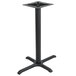 A BFM Seating black stamped steel table base with a black column on a table.