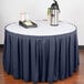 A table with a navy Snap Drape box pleat table skirt and a tray of food.