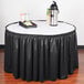 A black table with a Snap Drape black shirred pleat table skirt on it.