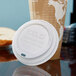 A white Eco-Products compostable plastic hot cup lid on a coffee cup.