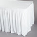 A white Snap Drape shirred pleat table skirt on a table.