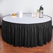 A table with a black Snap Drape table skirt on it.
