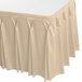 A cream Snap Drape table skirt with pleated bow tie pleats on a table with a white table cloth.