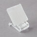 A clear plastic velcro clip with a white surface.