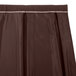 A brown box pleat table skirt with a white stripe.