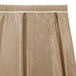 A beige Snap Drape box pleat table skirt with a white trim.
