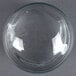 A clear glass sphere on a gray surface.