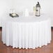 A table with a white Snap Drape box pleat table skirt with velcro clips.