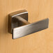 A close-up of a Bobrick stainless steel double robe hook with a satin finish.