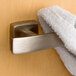 A towel hanging from a Bobrick double robe hook in a bathroom.