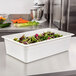 A container of salad in a white Cambro plastic food pan on a counter.
