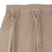 A beige Snap Drape Wyndham table skirt with bow tie pleats and Velcro clips.