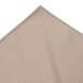 A beige Wyndham bow tie pleat table skirt with velcro clips.