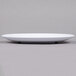 A white GET Milano melamine plate with a black rim on a gray surface.