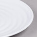 A close up of a white GET Milano melamine plate with a spiral design.