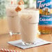 A glass of milkshake with Torani Sugar-Free Caramel Flavoring on top.