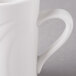 A close-up of a Libbey white porcelain coffee mug with a handle.
