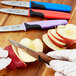 A person using a Mercer Culinary Millennia paring knife to cut an apple.