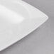 A close up of a white Libbey rectangular porcelain plate with a curved edge.