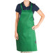 A woman wearing a Kelly green Chef Revival bib apron.