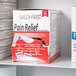 A box of Medi-First pain relief tablets on a shelf.