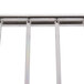 A close-up of a chrome metal bar with a white rectangular object in the background.