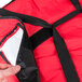A hand holding a red Rubbermaid insulated pizza delivery bag with a black strap.