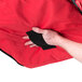 A hand holding a red Rubbermaid insulated pizza delivery bag with a black handle.