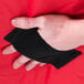 A hand holding a black wrist strap on a red Rubbermaid insulated delivery bag.