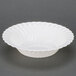 A white Fineline Flairware plastic bowl with scalloped edges.