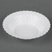 A white bowl with a scalloped edge.