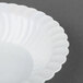 A close up of a white Fineline Flairware plastic bowl with a scalloped edge.
