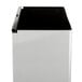A stainless steel Bobrick rectangular recessed trash can with a black lid.