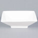 A close-up of a CAC Citysquare bright white square porcelain bowl.