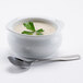 A bowl of Silver Skillet cream of mushroom soup with a spoon and a green leaf on top.