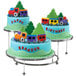 A Wilton three-tiered display stand with train themed cakes on it.