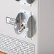 A close-up of a metal switch on a Bunn coffee brewer.