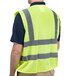 A man wearing a Cordova lime yellow high visibility safety vest over a black shirt.