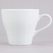 A close-up of the handle of a Tuxton porcelain white cappuccino mug.